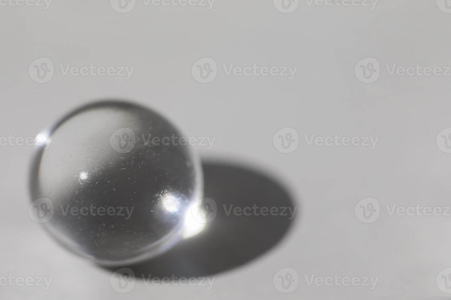 Glass ball on gray background with shadow photo