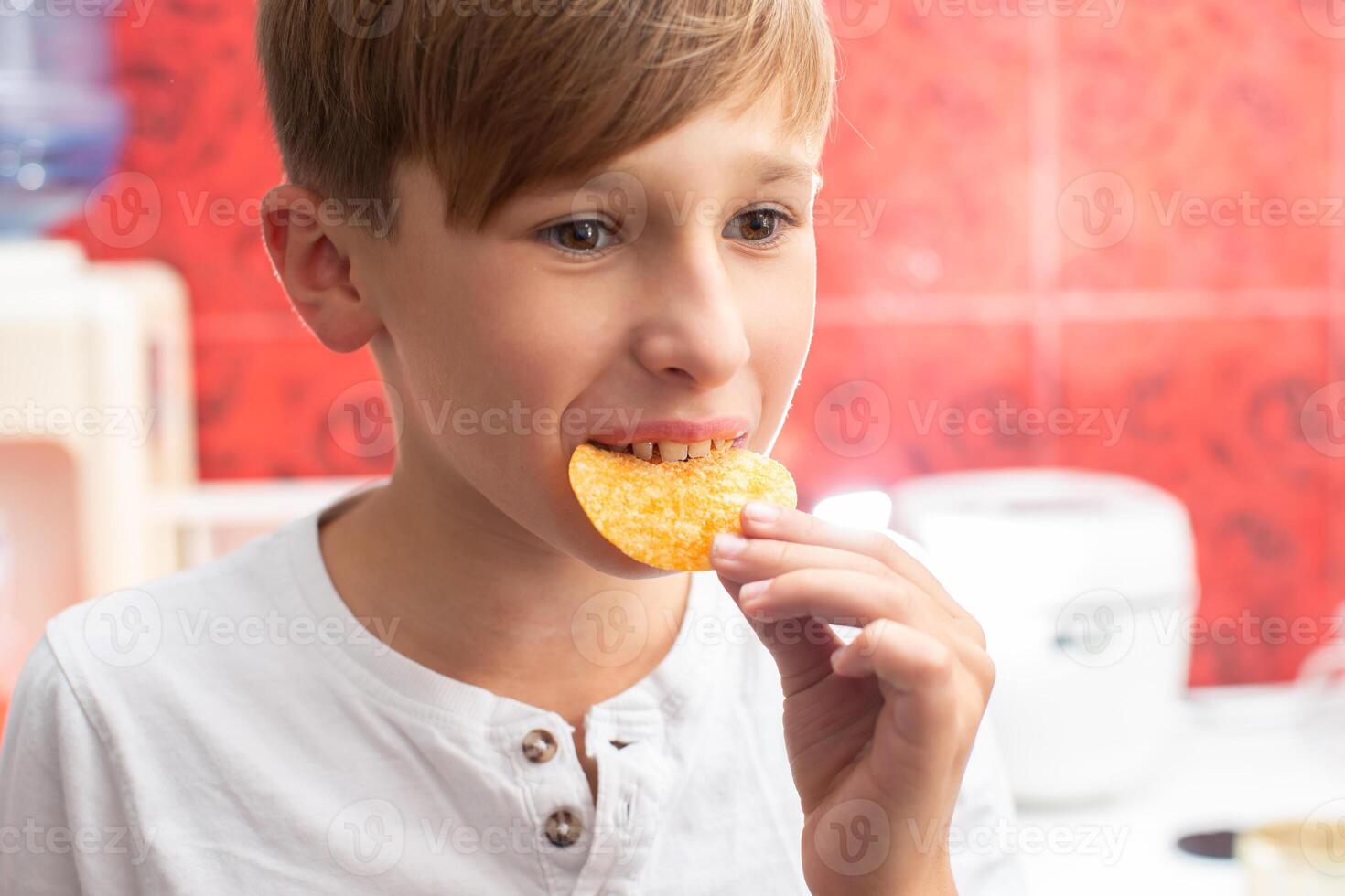 chico comiendo papas fritas de cerca. patata chip niño. foto