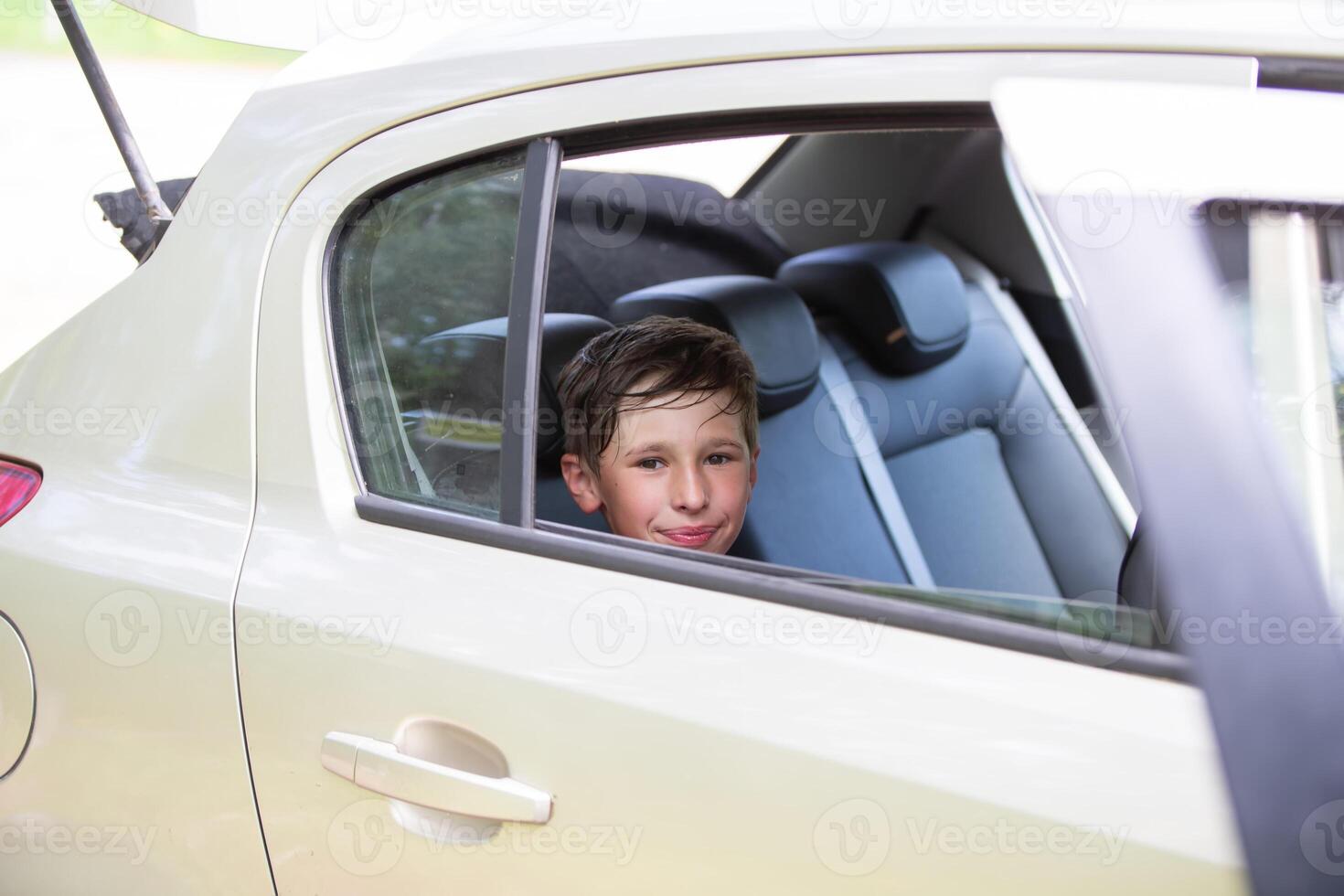 Cheerful joyful child in the car while traveling. photo