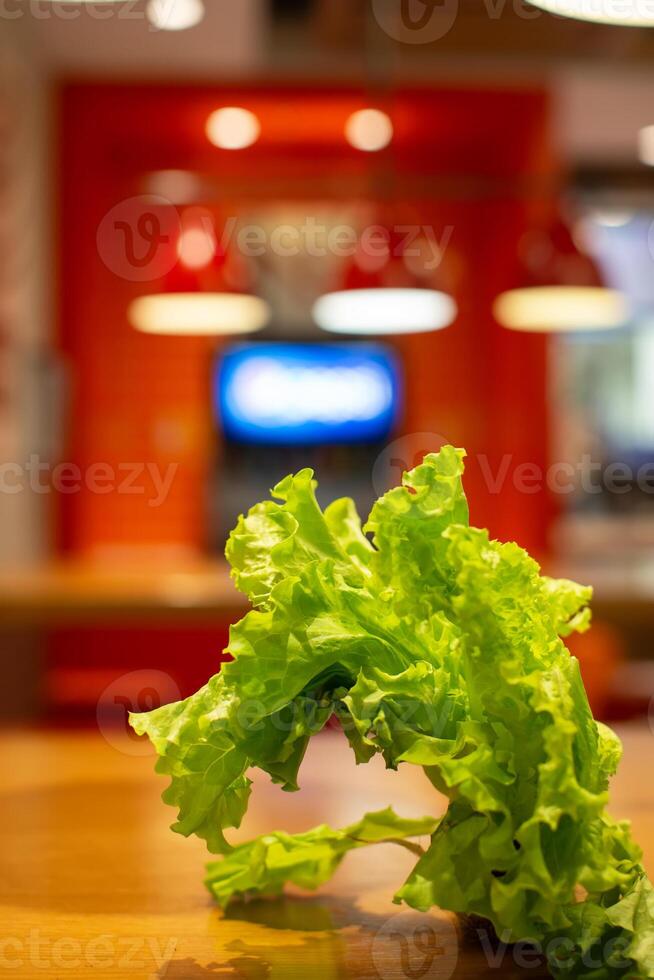 verde lechuga hoja en borroso cocina antecedentes. sano comiendo y vegetarianismo. foto