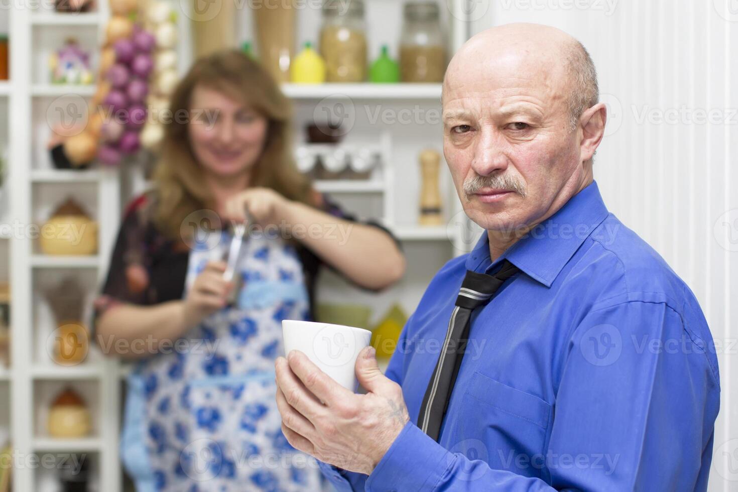 mayor hombre con un taza en el antecedentes de su esposa foto