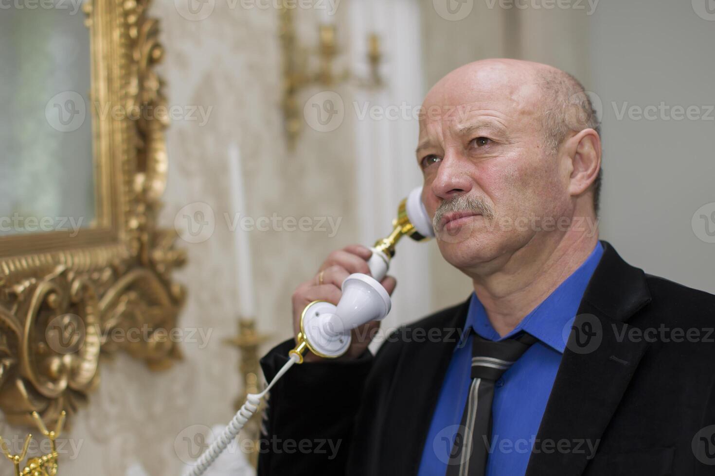 Elegant elderly man with a retro phone photo