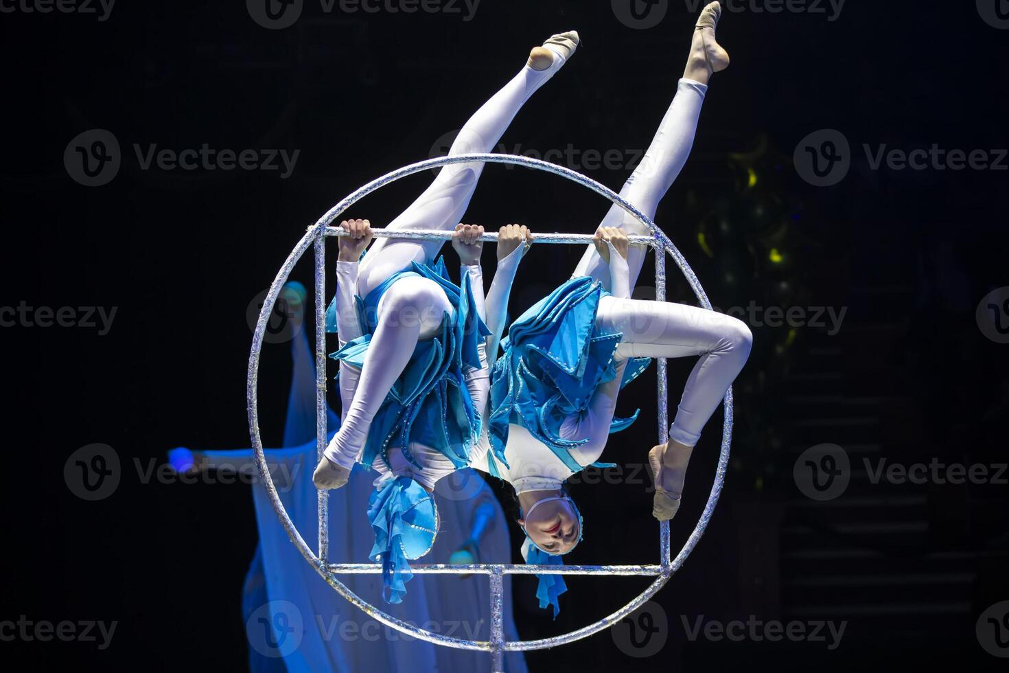 dos acróbata muchachas espectáculo un circo número en un oscuro antecedentes. acrobático actuación. foto