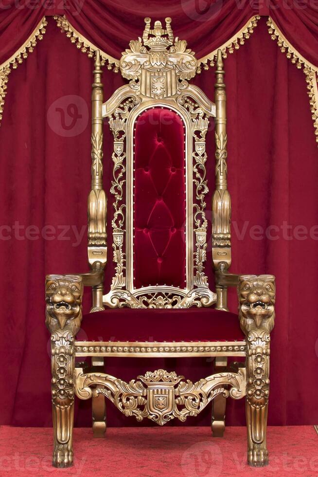 Red royal chair on a background of red curtains. Place for the king. Throne photo