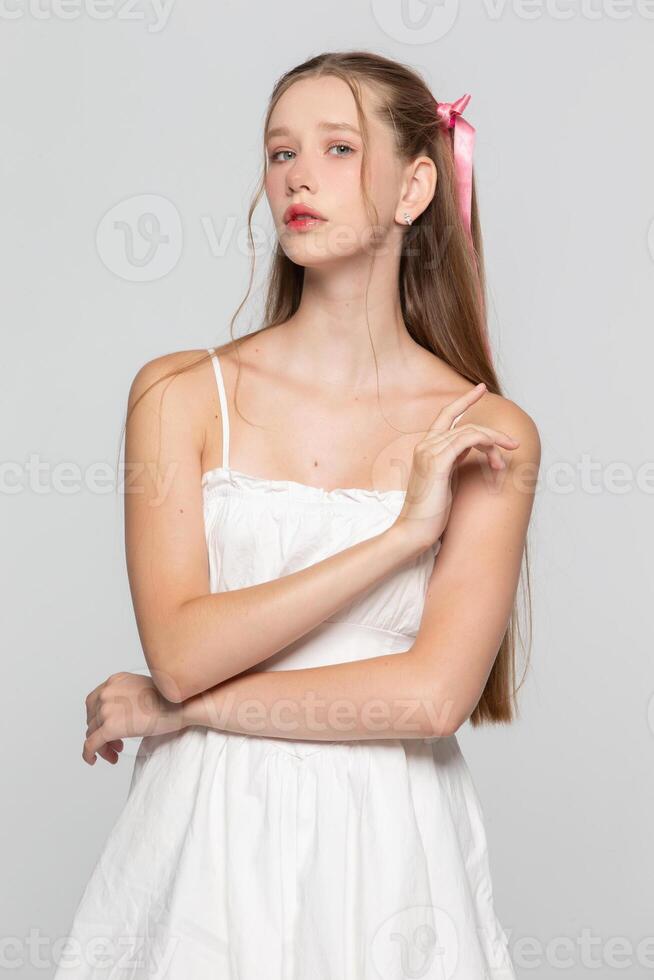 Portrait of a cute romantic young seventeen year old girl on a gray background. photo