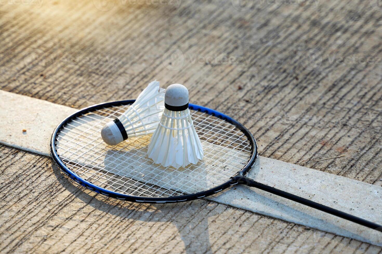 White shuttlecock 2 Placed side by side on a badminton racket with a cement background.soft and selective focus photo