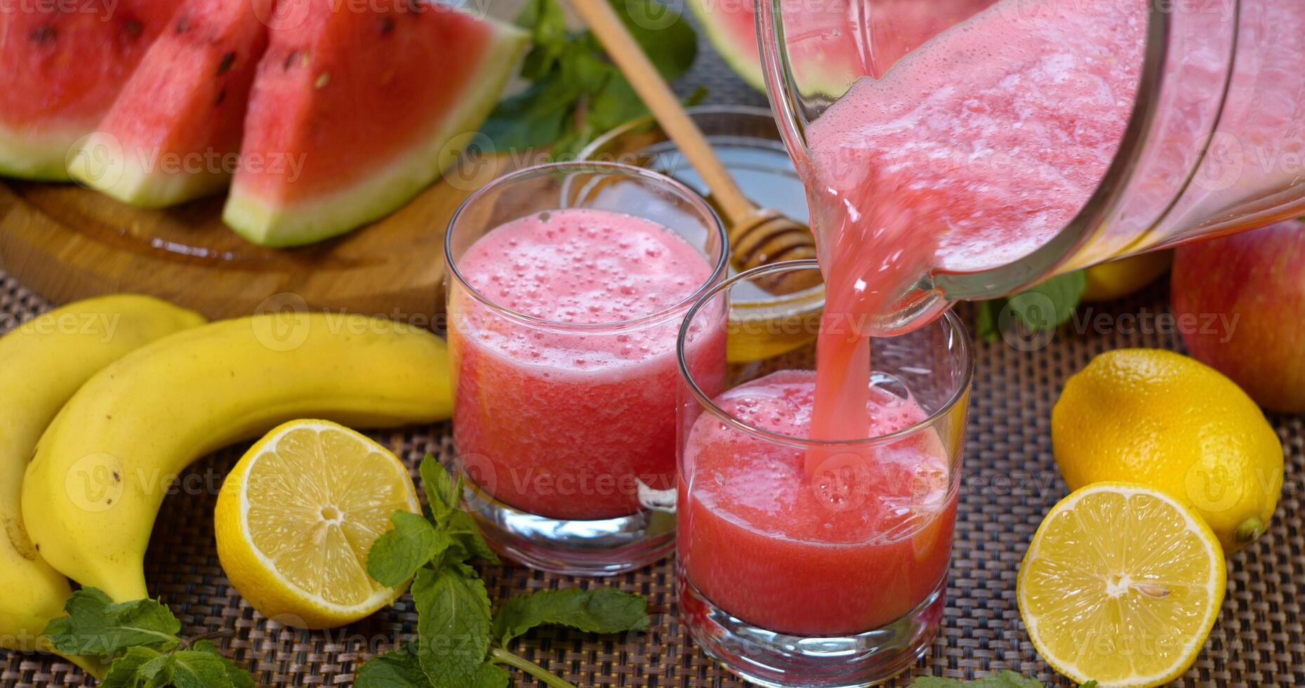 sandía plátano zalamero es vertido dentro un vaso en el antecedentes de Fresco frutas el Fruta cóctel es Listo a comer. sano y vegetariano comida concepto. foto