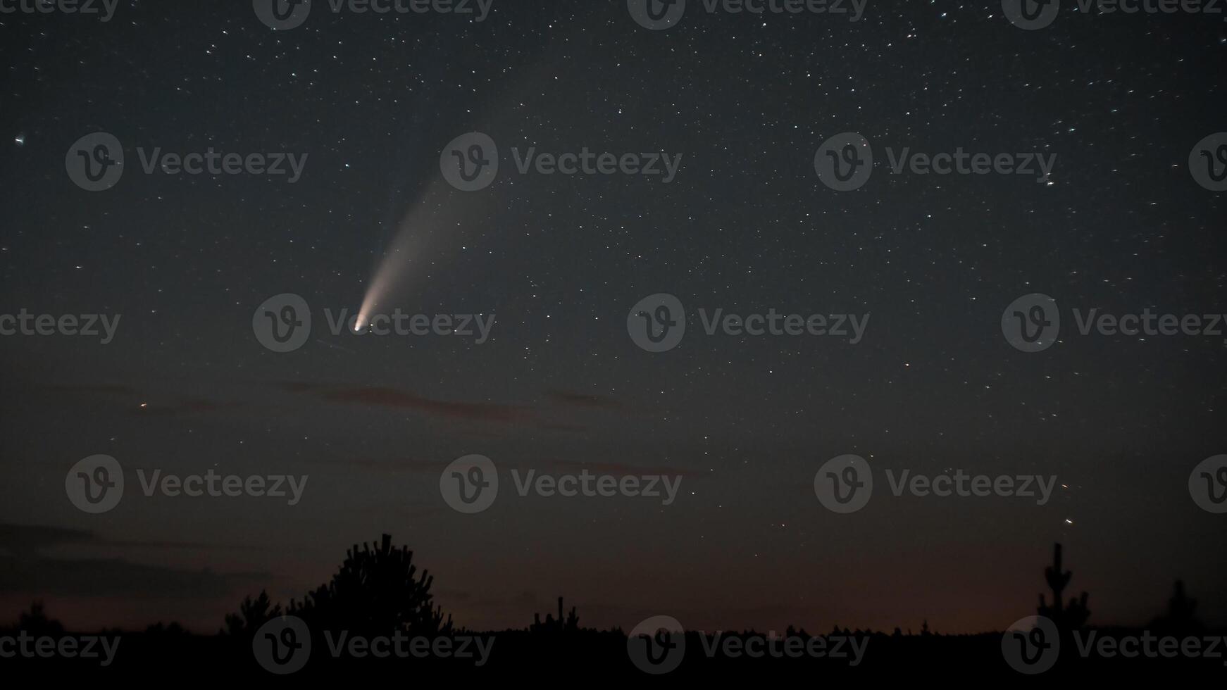 Comet NEOWISE moves across the night sky among the stars photo