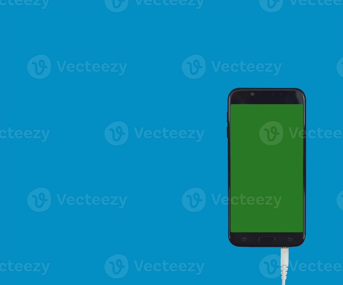 Phone mobile telephone with a vertical green screen in tram chroma key smartphone technology cell phone on blue background isolate photo