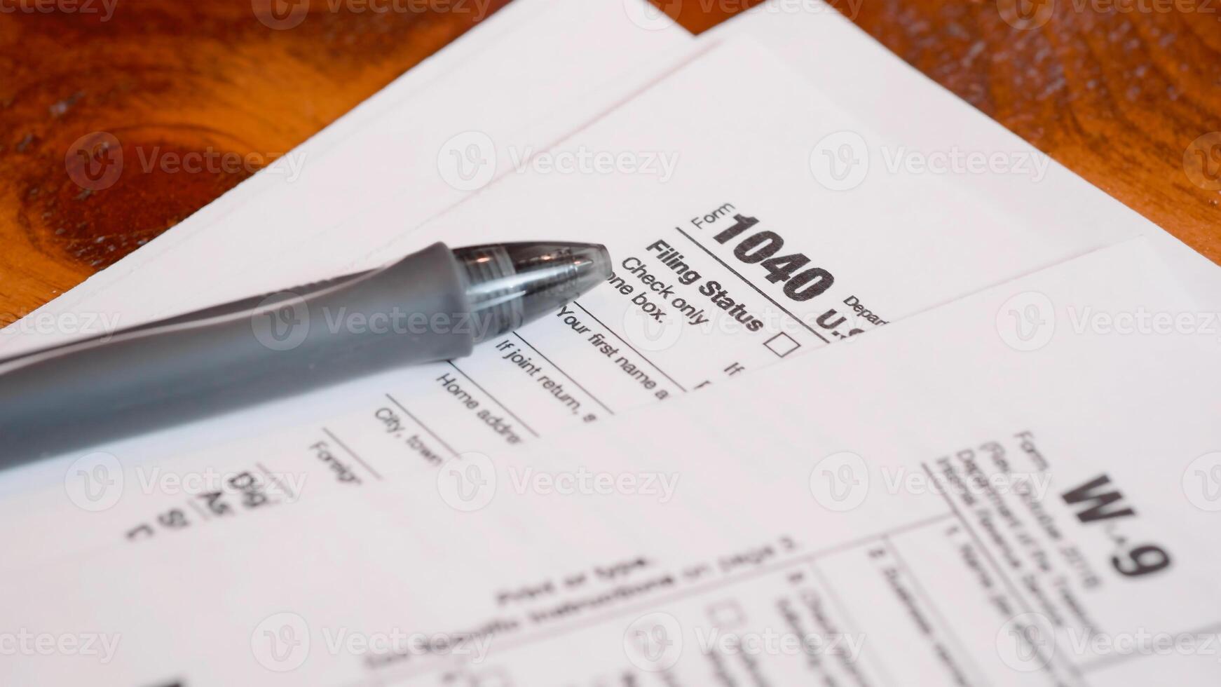Tax form 1040 and W9 on a table, shallow depth of field photo