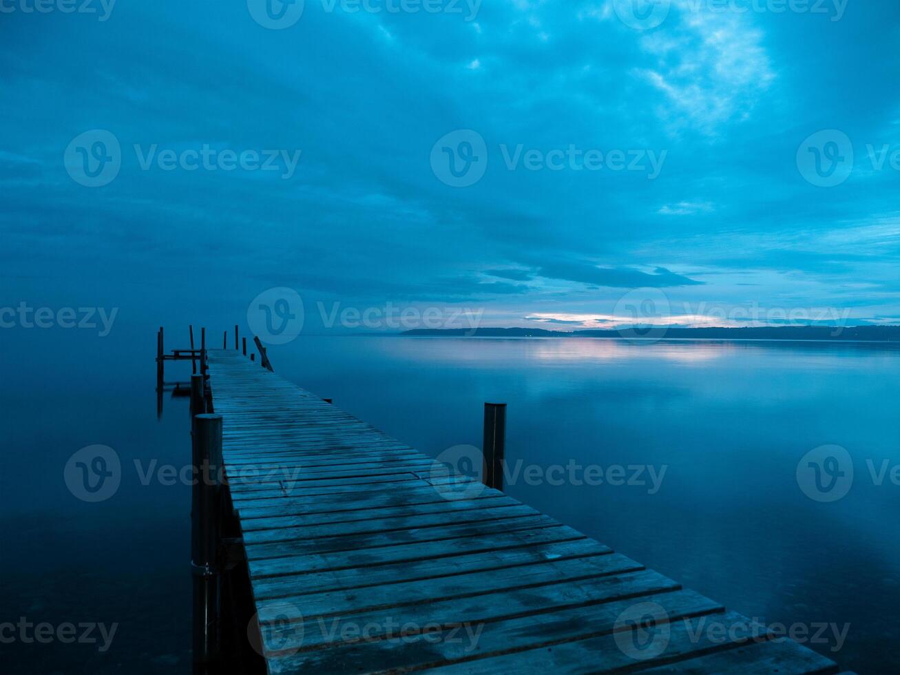 Perfecto simetría, un de madera embarcadero en un lago a amanecer en el Mañana foto