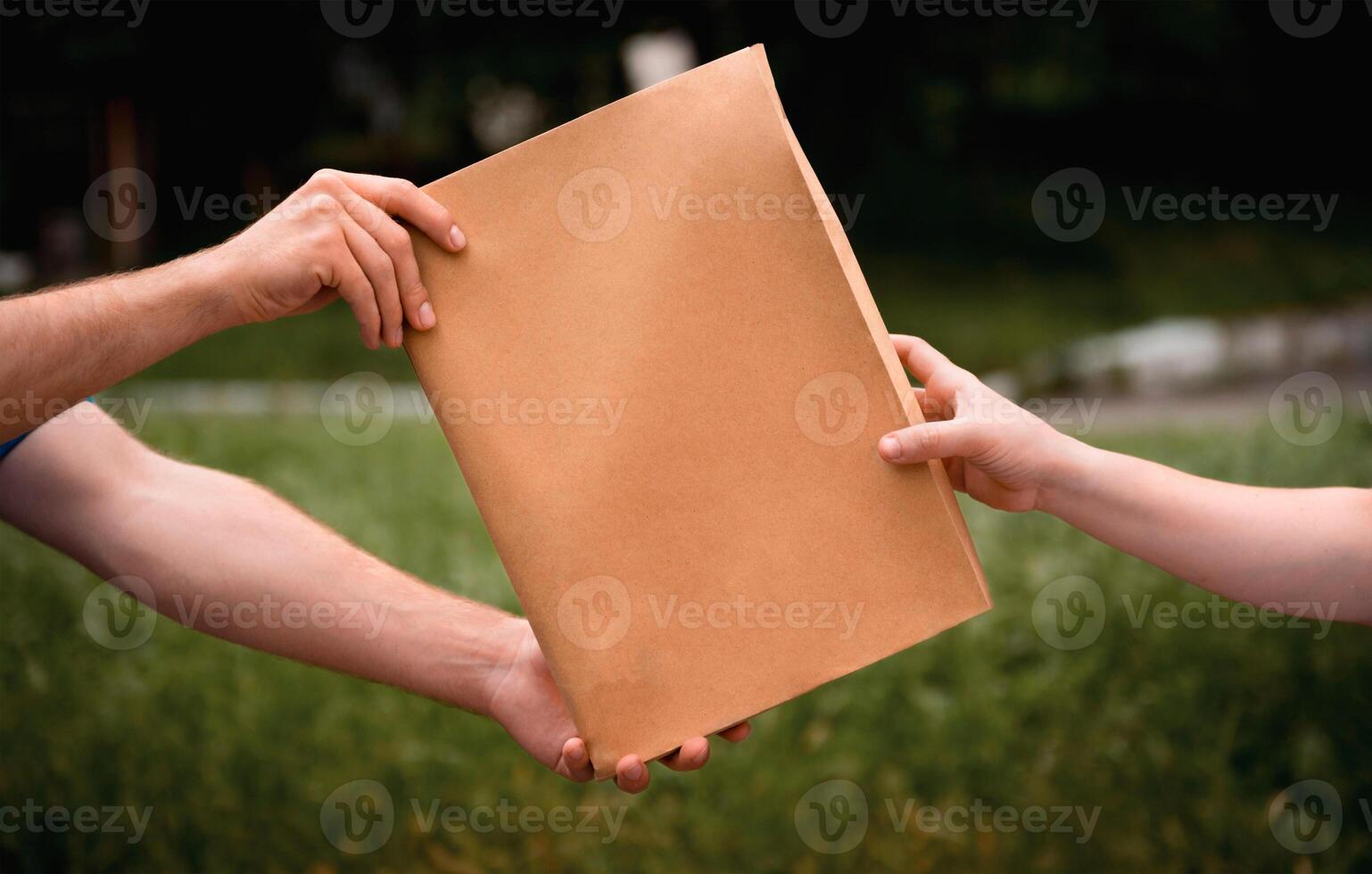 dos manos sosteniendo papel marrón en blanco aislado en fondo blanco con trazado de recorte foto