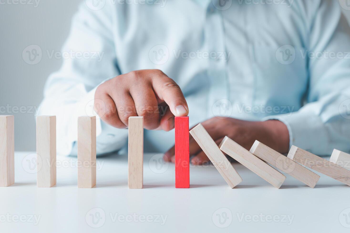 Businessman protect wooden block ,Business risks in the business. Requires planning Meditation must be careful in deciding to reduce the risk in the business. photo