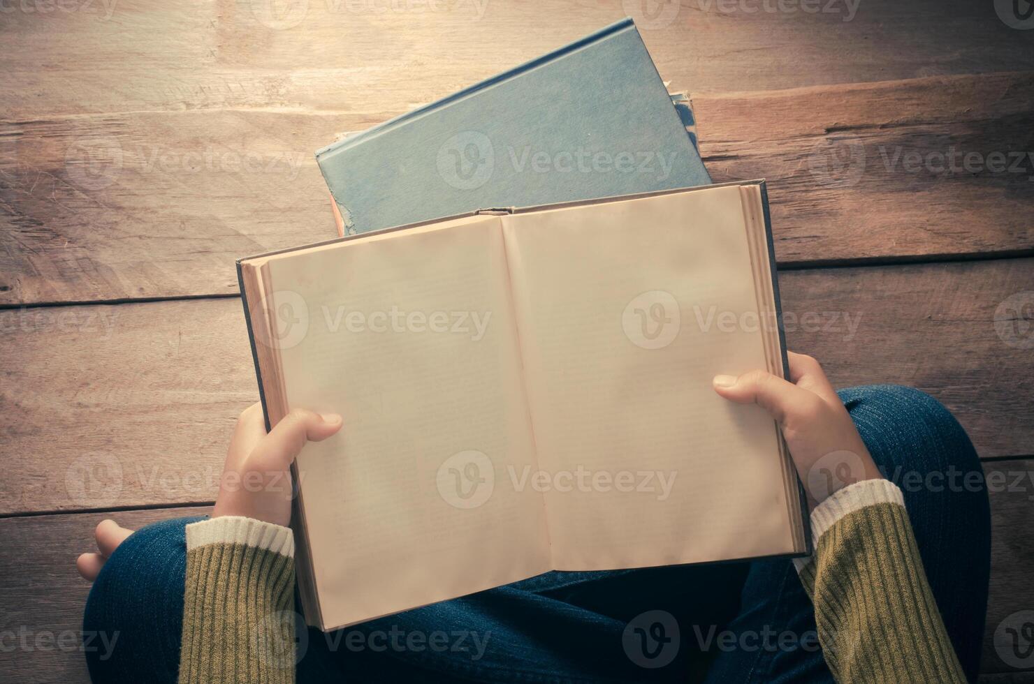 reading book on wooden floor with book - tone vintage photo