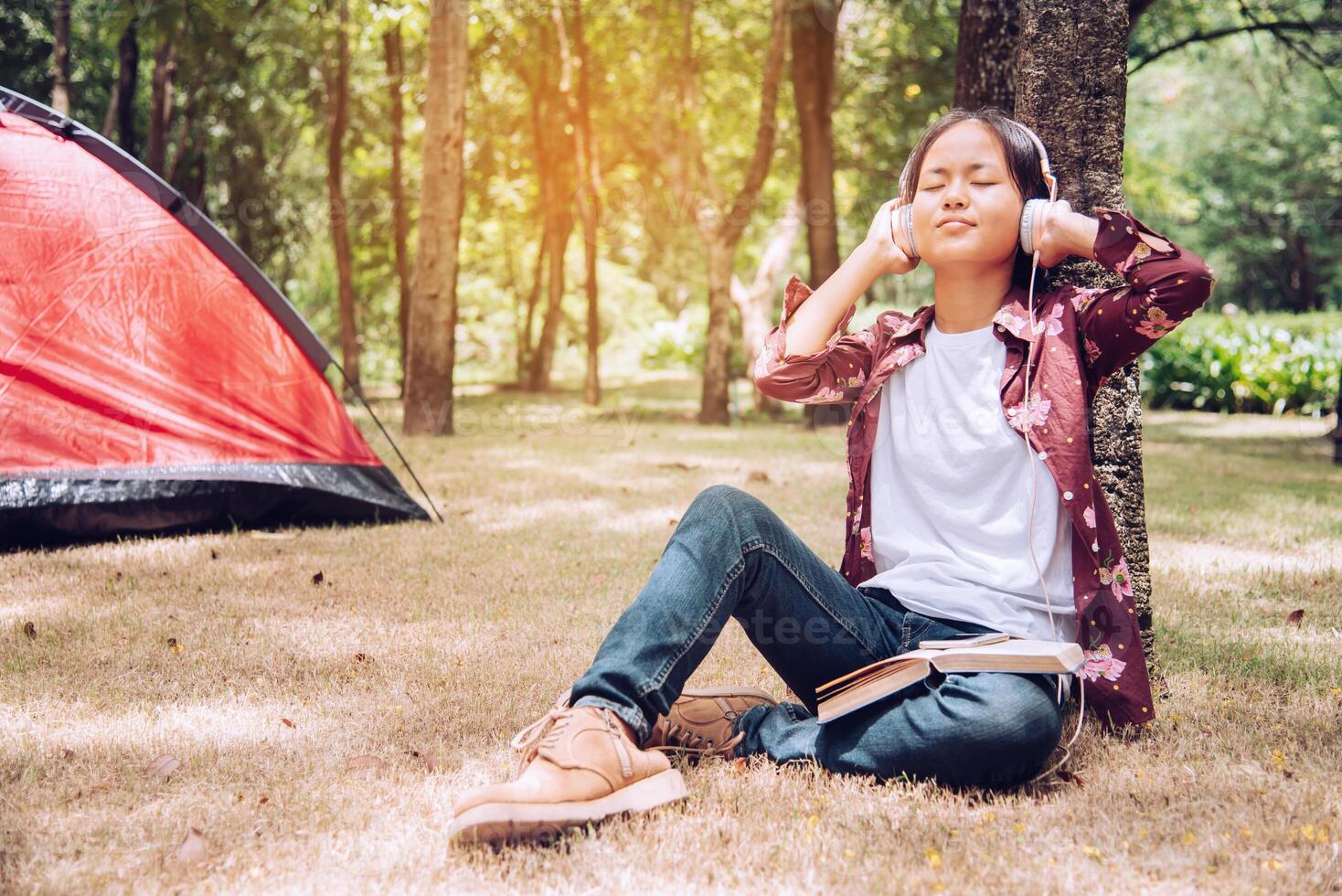Teens are relaxing and happy by listening to music in the picnic area. photo