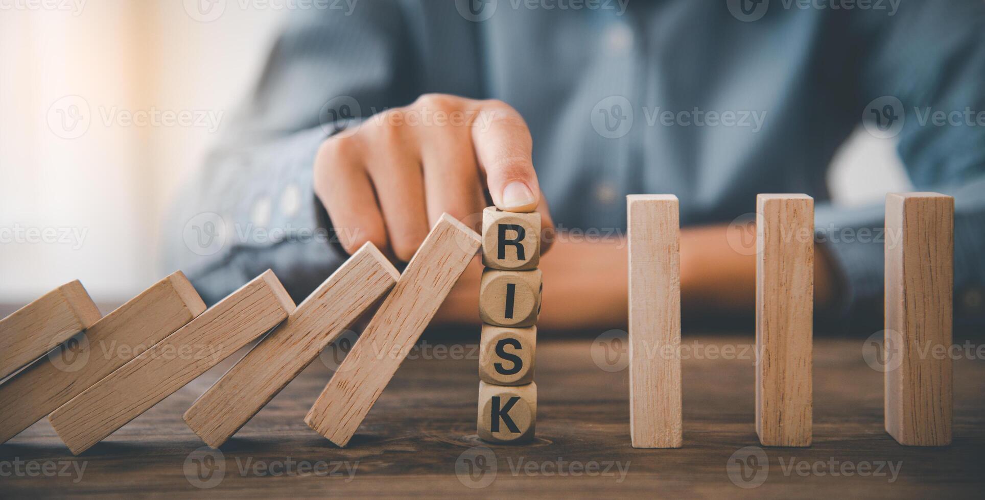 close-up hand The hand of a businessman who is stopping or preventing a falling block.Risk protection concept,Eliminating the risk photo