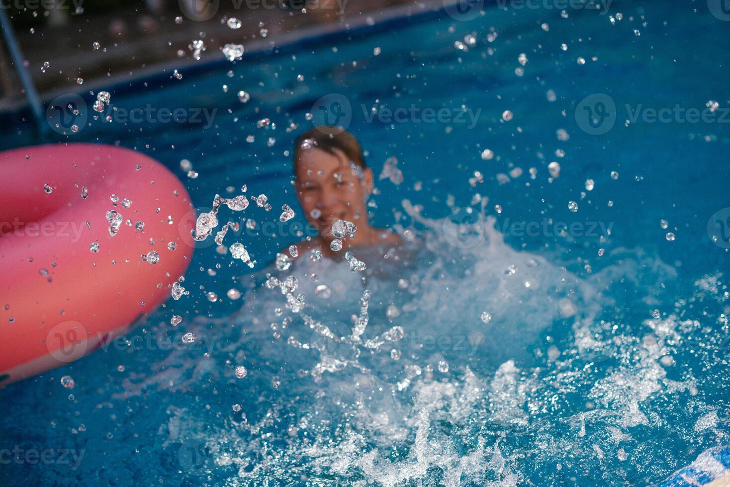 a child in a pool with an inflatable ring photo