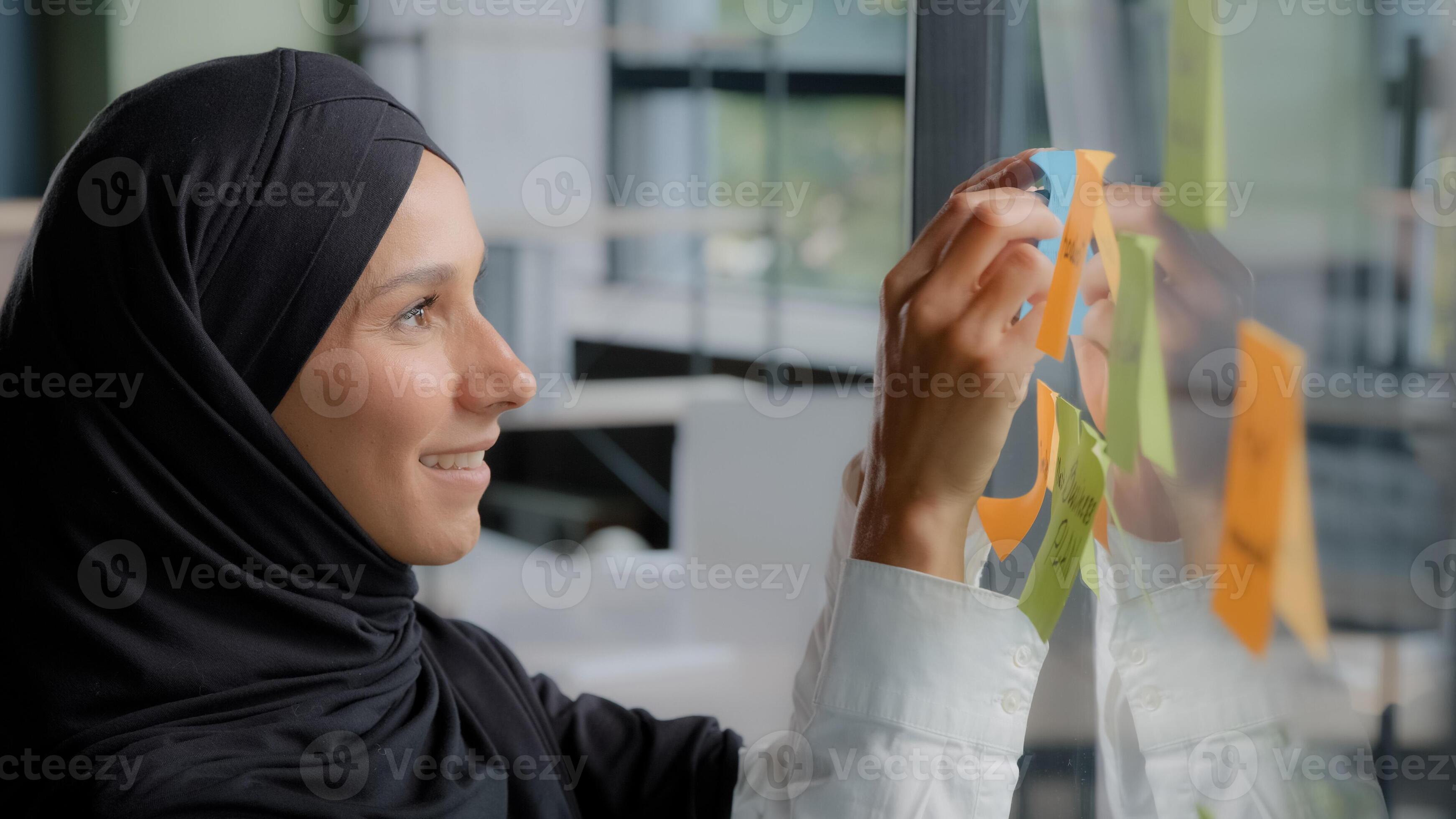 Smiling successful businesswoman corporate leader writing project tasks