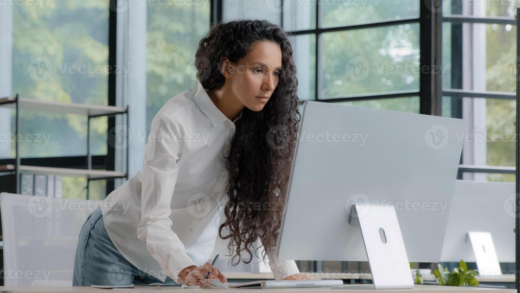 Busy successful businesswoman working in office writing data from computer beautiful female professional creative manager develops plan for development of new project writes tasks using application photo