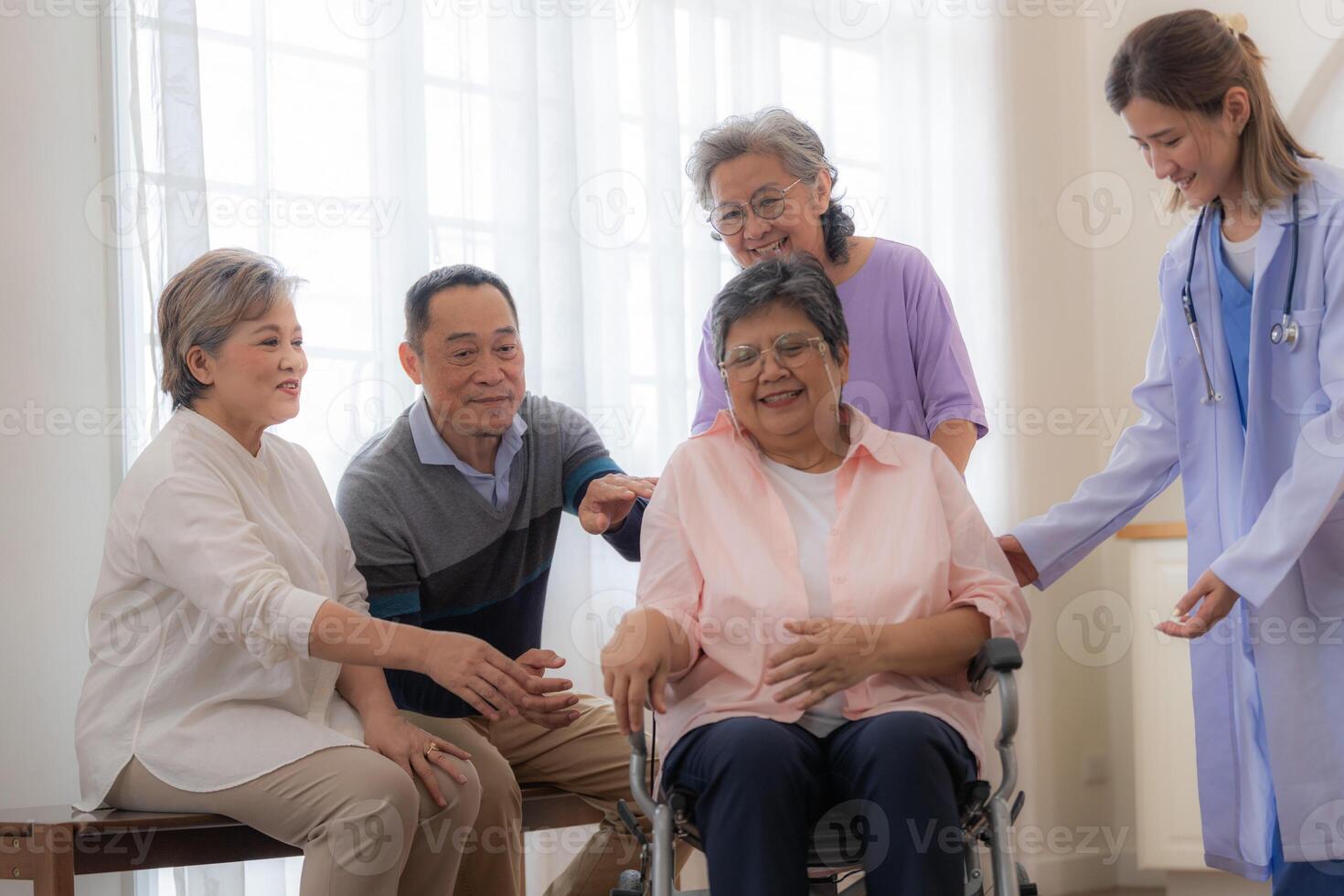 asiático joven enfermero apoyo Pareja mayor más viejo mujer en un silla de ruedas. mayor maduro y un grupo de mayor amigos vivo en el hospital. socializando de retirado gente. foto