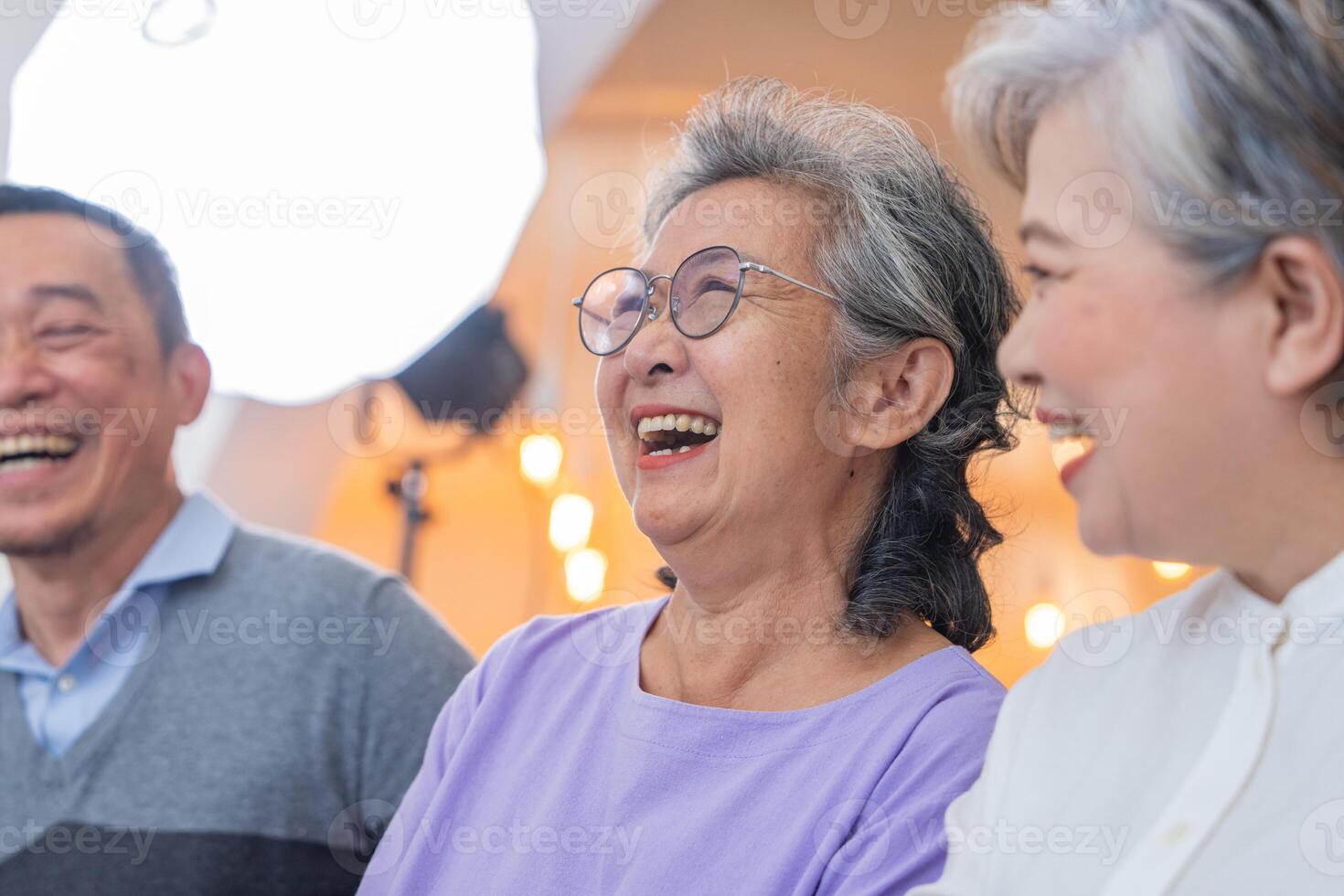 close up senior females and male sitting on bench. older people are listening and enjoy meeting focus group at living room. Joyful carefree retired senior friends enjoying relaxation at nearly home. photo