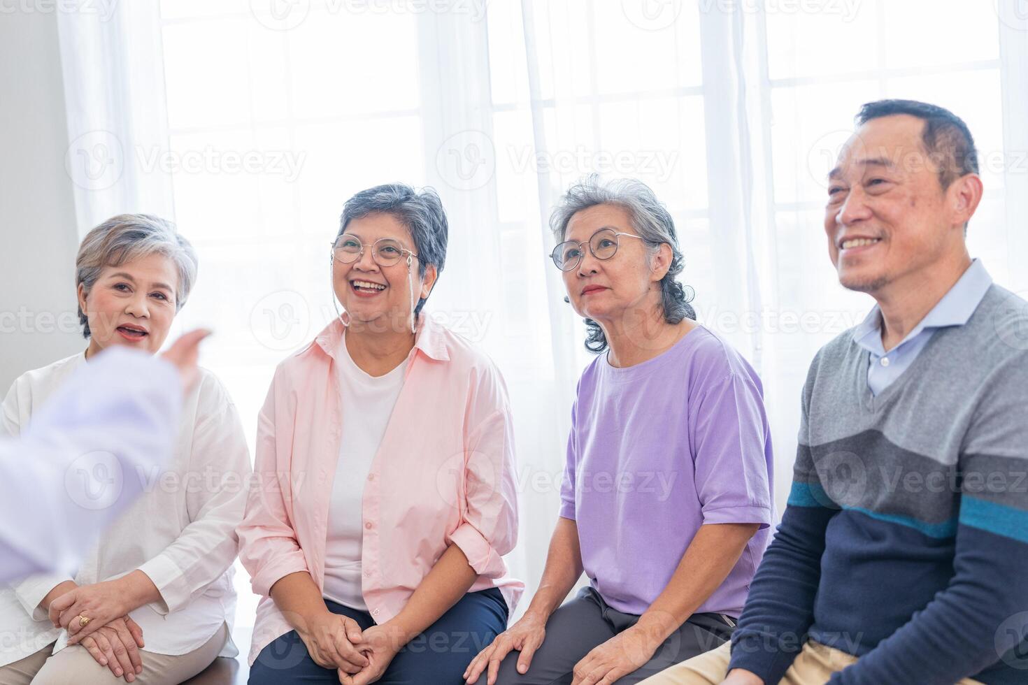 senior females and male sitting on bench. older people are listening and enjoy meeting focus group at living room. Joyful carefree retired senior friends enjoying relaxation at nearly home. photo