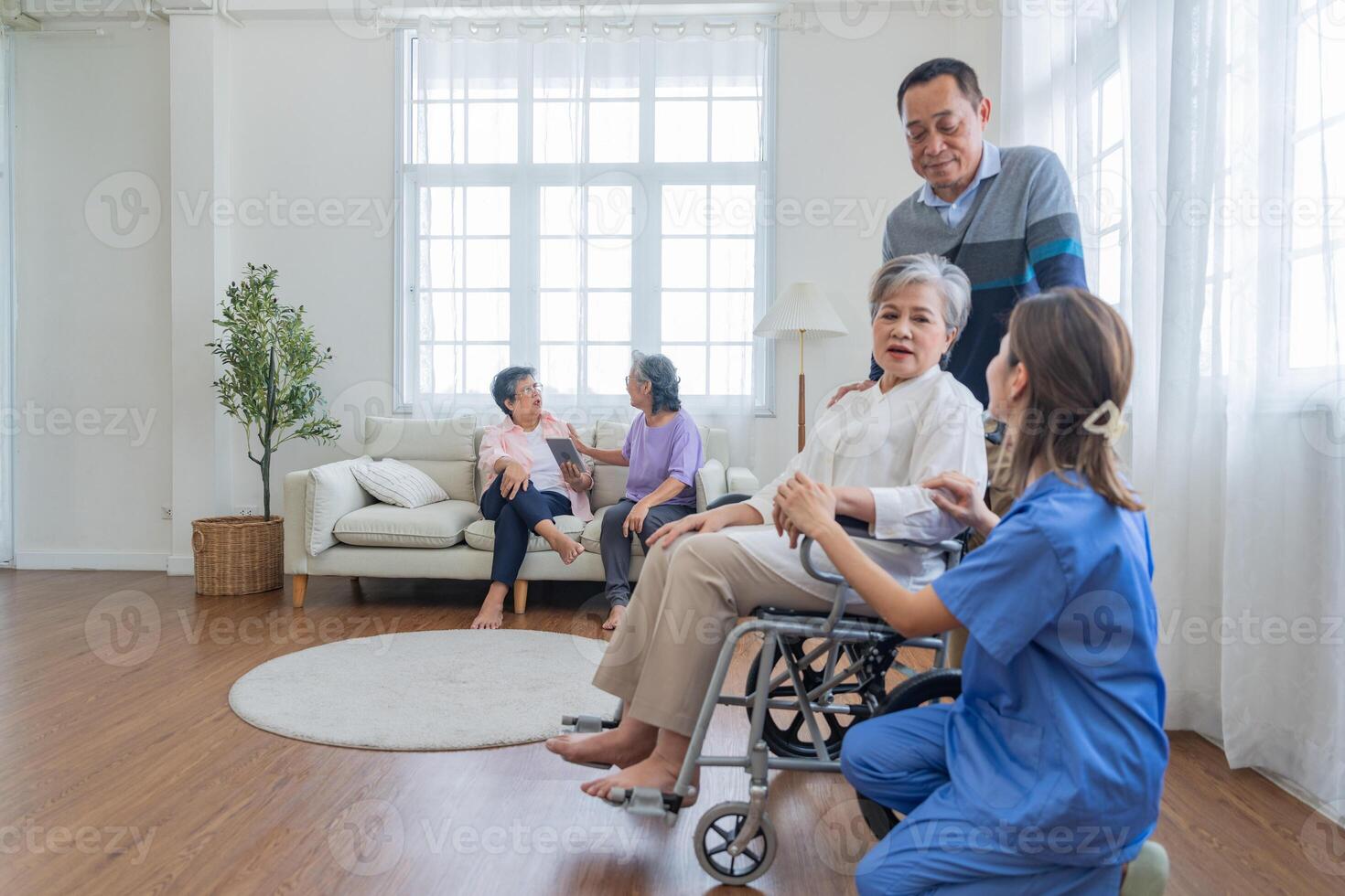 Asian young nurse support couple senior older man and woman in a wheelchair. elderly mature and a group of senior friends living in the hospital. socializing of retired people. photo