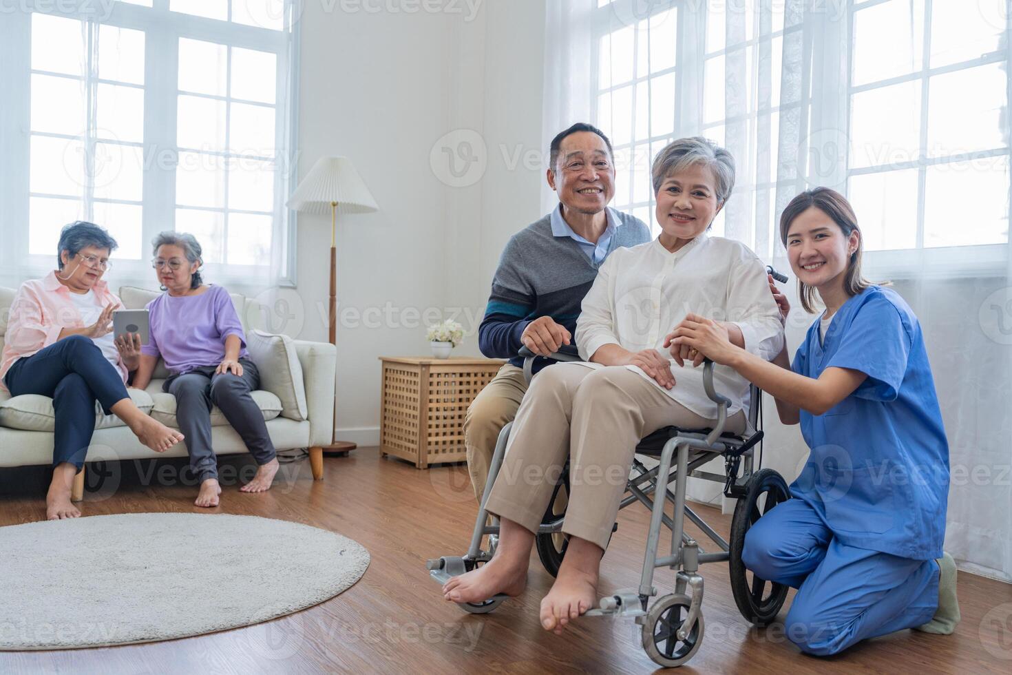 Asian young nurse support couple senior older man and woman in a wheelchair. elderly mature and a group of senior friends living in the hospital. socializing of retired people. photo