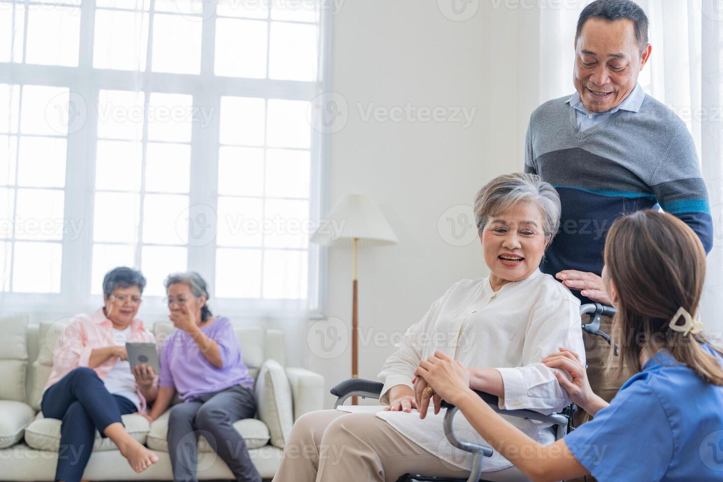 Asian young nurse support couple senior older man and woman in a wheelchair. elderly mature and a group of senior friends living in the hospital. socializing of retired people. photo