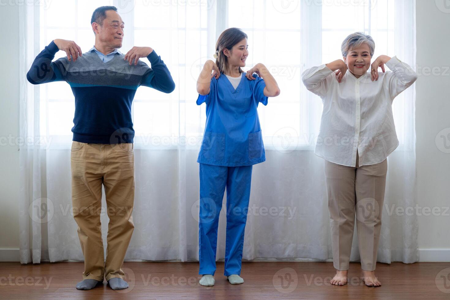 Portrait of elderly smiling Asian woman and people aerobics in nursery house. Seniors are moving their body arms and shoulders for a healthy life. retired people activities group concept. photo