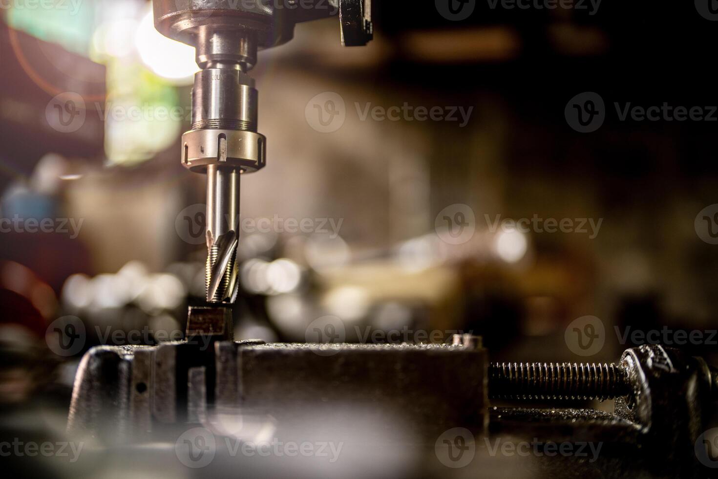 close up metal drill bit stay position for make holes in steel mold. Metal industry. milling process with metal plate parts on CNC milling machine. shop floor milling operation by milling machine. photo