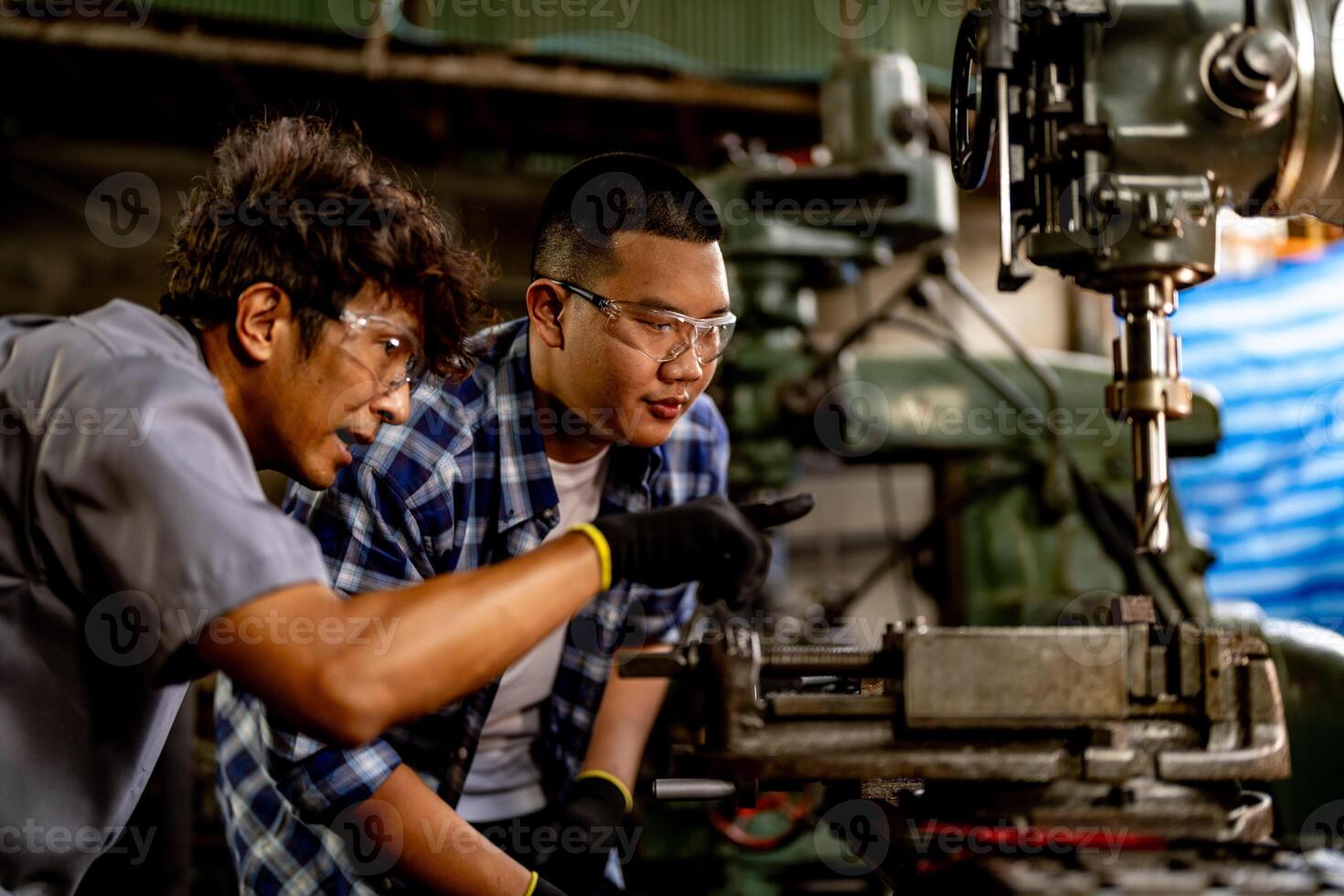 Asian worker in production plant drilling at machine. Professional worker near drilling machine on factory. finishing metal working internal steel surface on lathe grinder machine with flying sparks. photo