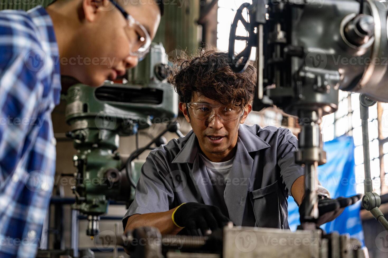 asiático trabajador en producción planta perforación a máquina. profesional trabajador cerca perforación máquina en fábrica. refinamiento metal trabajando interno acero superficie en torno amoladora máquina con volador chispas. foto