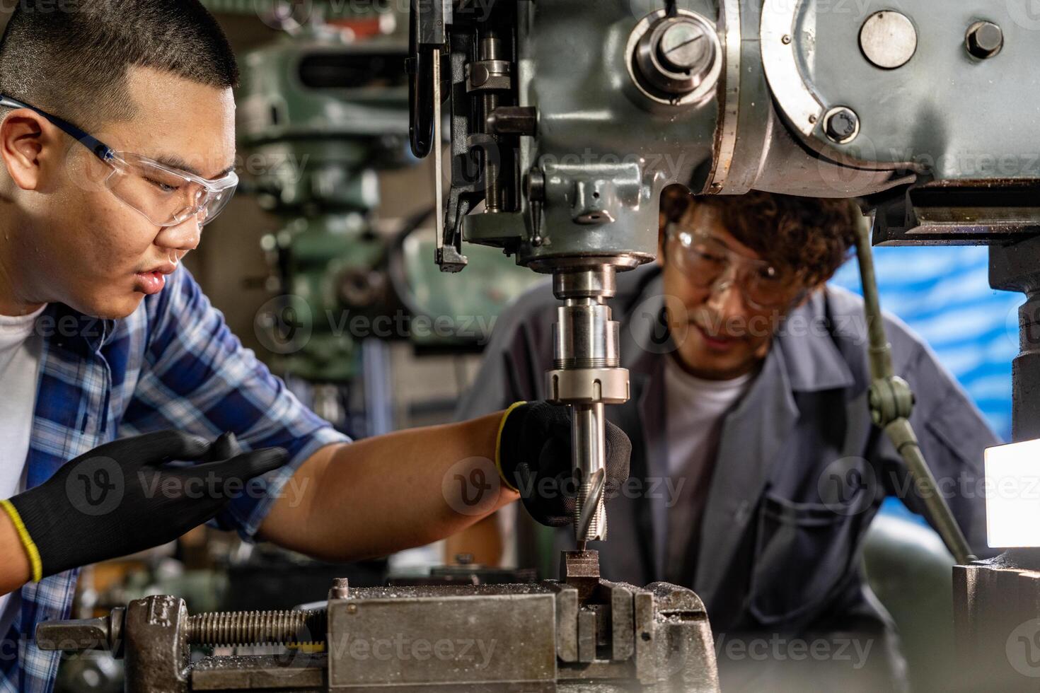 Asian worker in production plant drilling at machine. Professional worker near drilling machine on factory. finishing metal working internal steel surface on lathe grinder machine with flying sparks. photo
