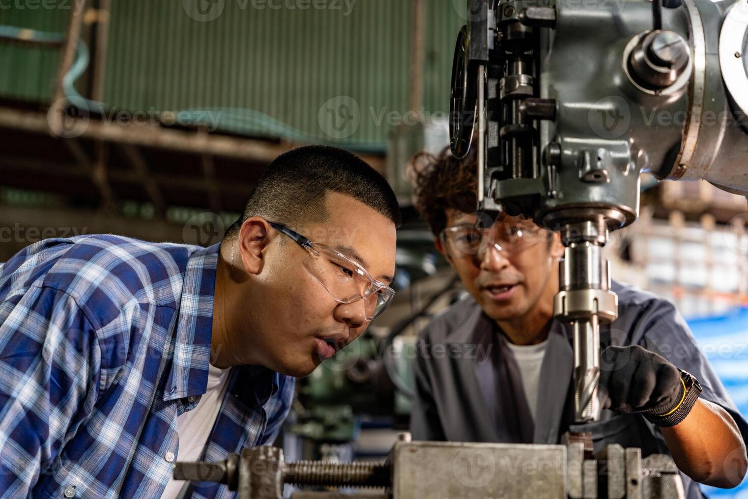 asiático trabajador en producción planta perforación a máquina. profesional trabajador cerca perforación máquina en fábrica. refinamiento metal trabajando interno acero superficie en torno amoladora máquina con volador chispas. foto