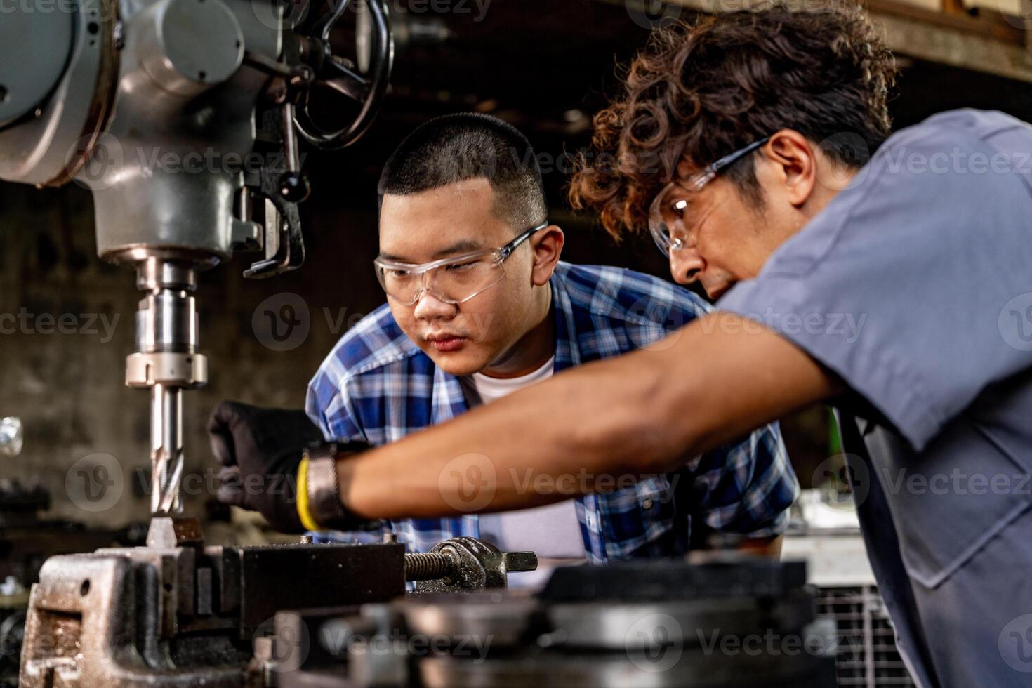 asiático trabajador en producción planta perforación a máquina. profesional trabajador cerca perforación máquina en fábrica. refinamiento metal trabajando interno acero superficie en torno amoladora máquina con volador chispas. foto