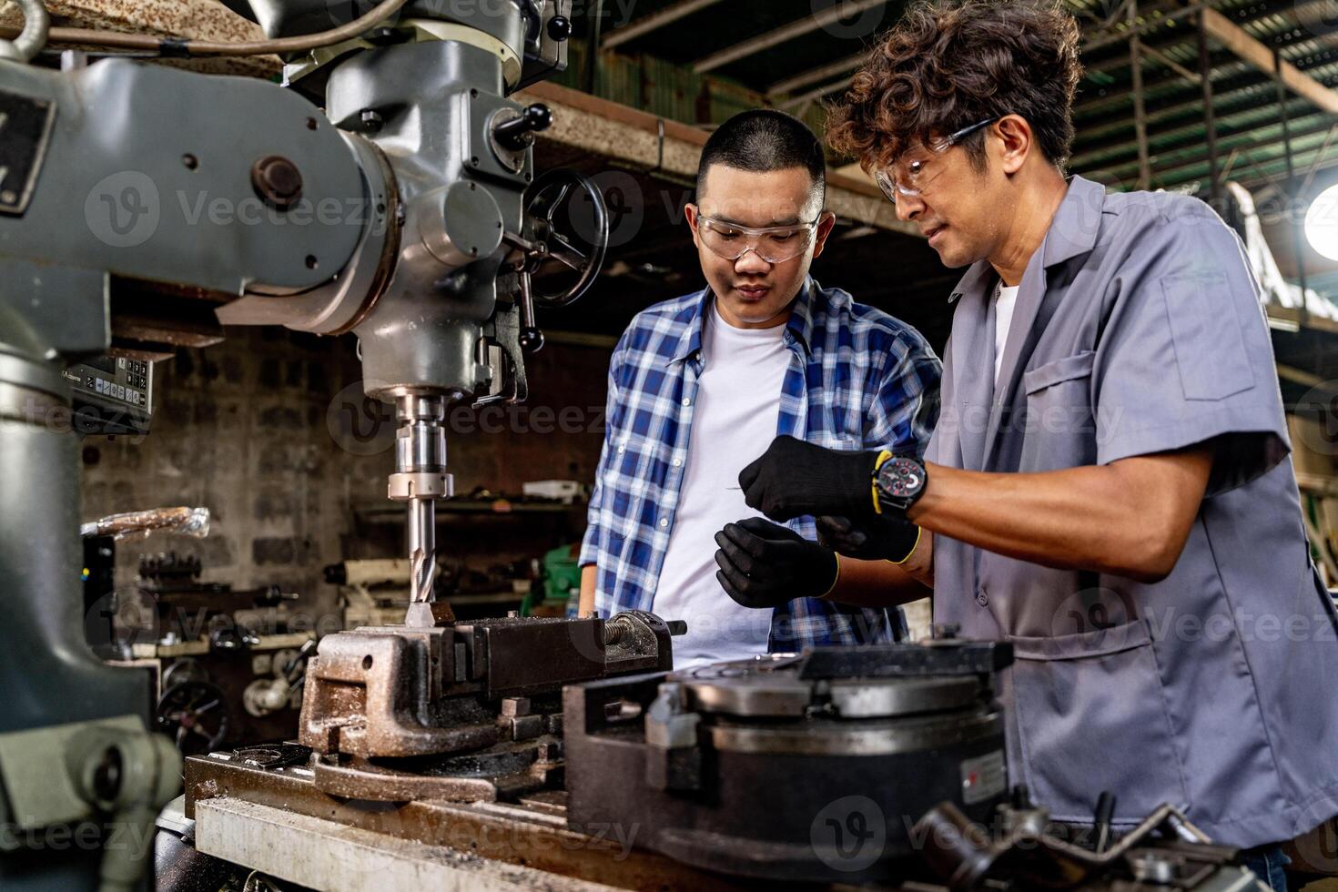 asiático trabajador en producción planta perforación a máquina. profesional trabajador cerca perforación máquina en fábrica. refinamiento metal trabajando interno acero superficie en torno amoladora máquina con volador chispas. foto