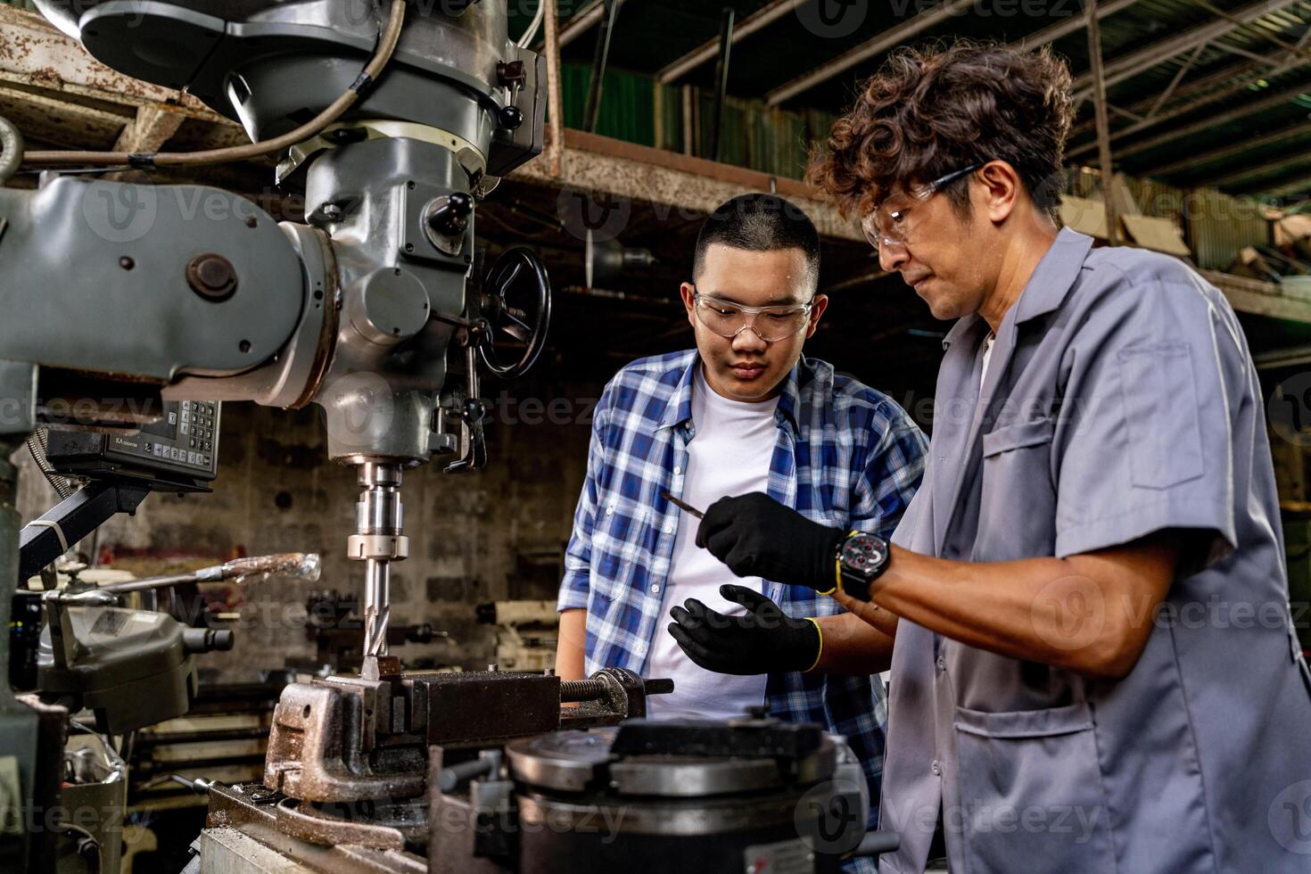 asiático trabajador en producción planta perforación a máquina. profesional trabajador cerca perforación máquina en fábrica. refinamiento metal trabajando interno acero superficie en torno amoladora máquina con volador chispas. foto