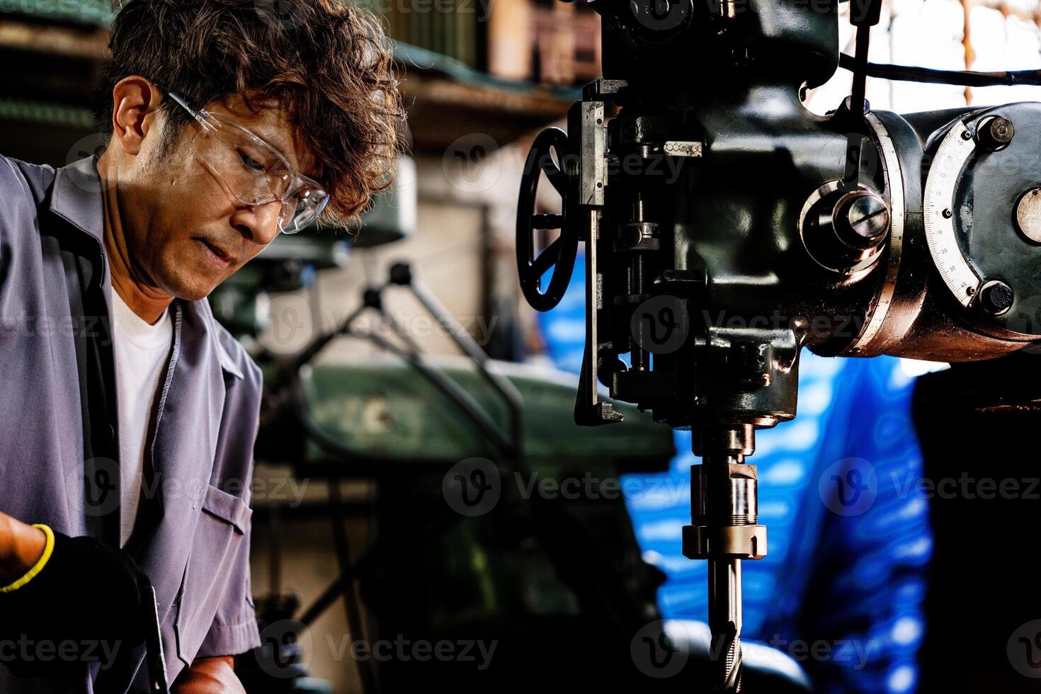 Engineer worker in production plant drilling at machine. Professional worker near drilling machine on factory. man inspecting and repairing machine for operation in workshop. photo