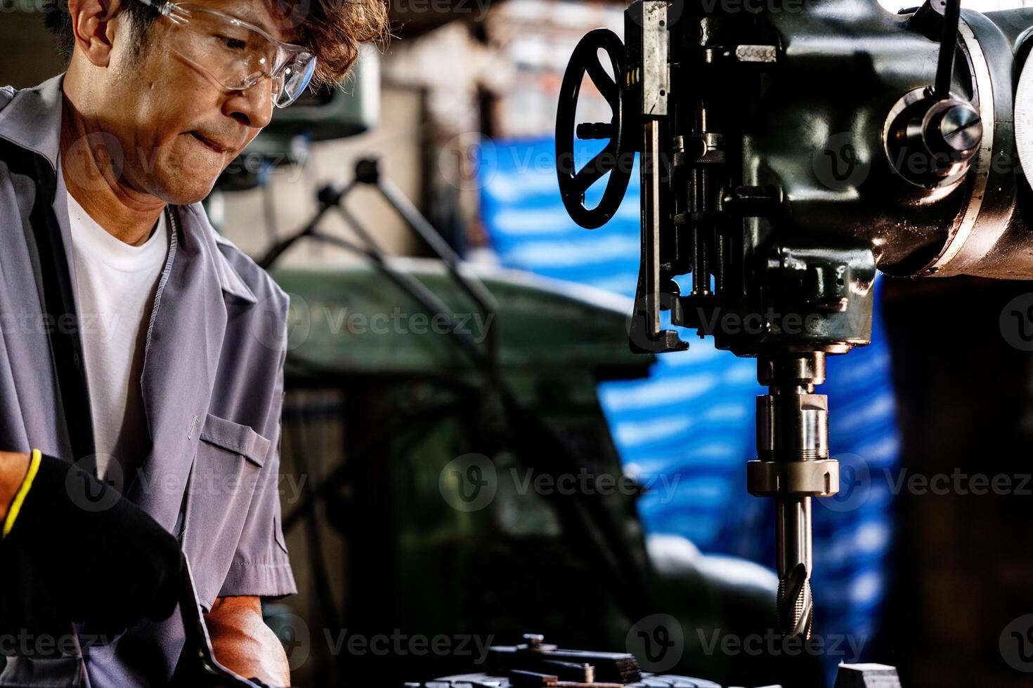 ingeniero trabajador en producción planta perforación a máquina. profesional trabajador cerca perforación máquina en fábrica. hombre inspeccionando y reparando máquina para operación en taller. foto