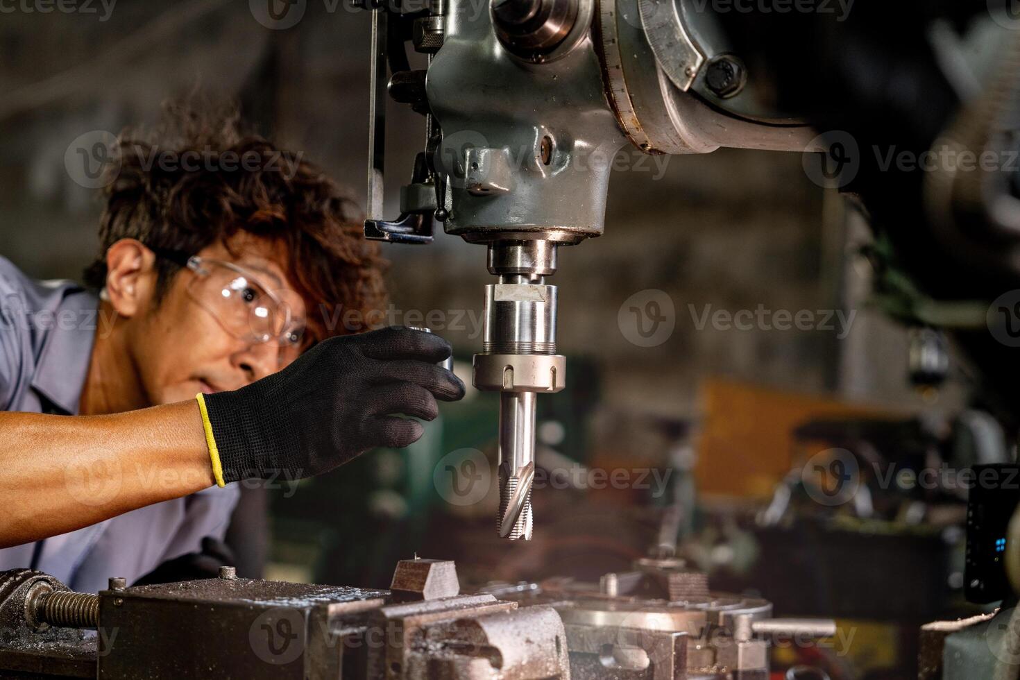 Engineer worker in production plant drilling at machine. Professional worker near drilling machine on factory. man inspecting and repairing machine for operation in workshop. photo