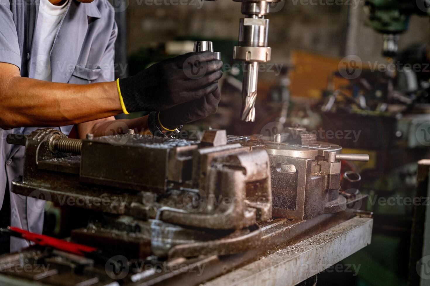 Engineer worker in production plant drilling at machine. Professional worker near drilling machine on factory. man inspecting and repairing machine for operation in workshop. photo