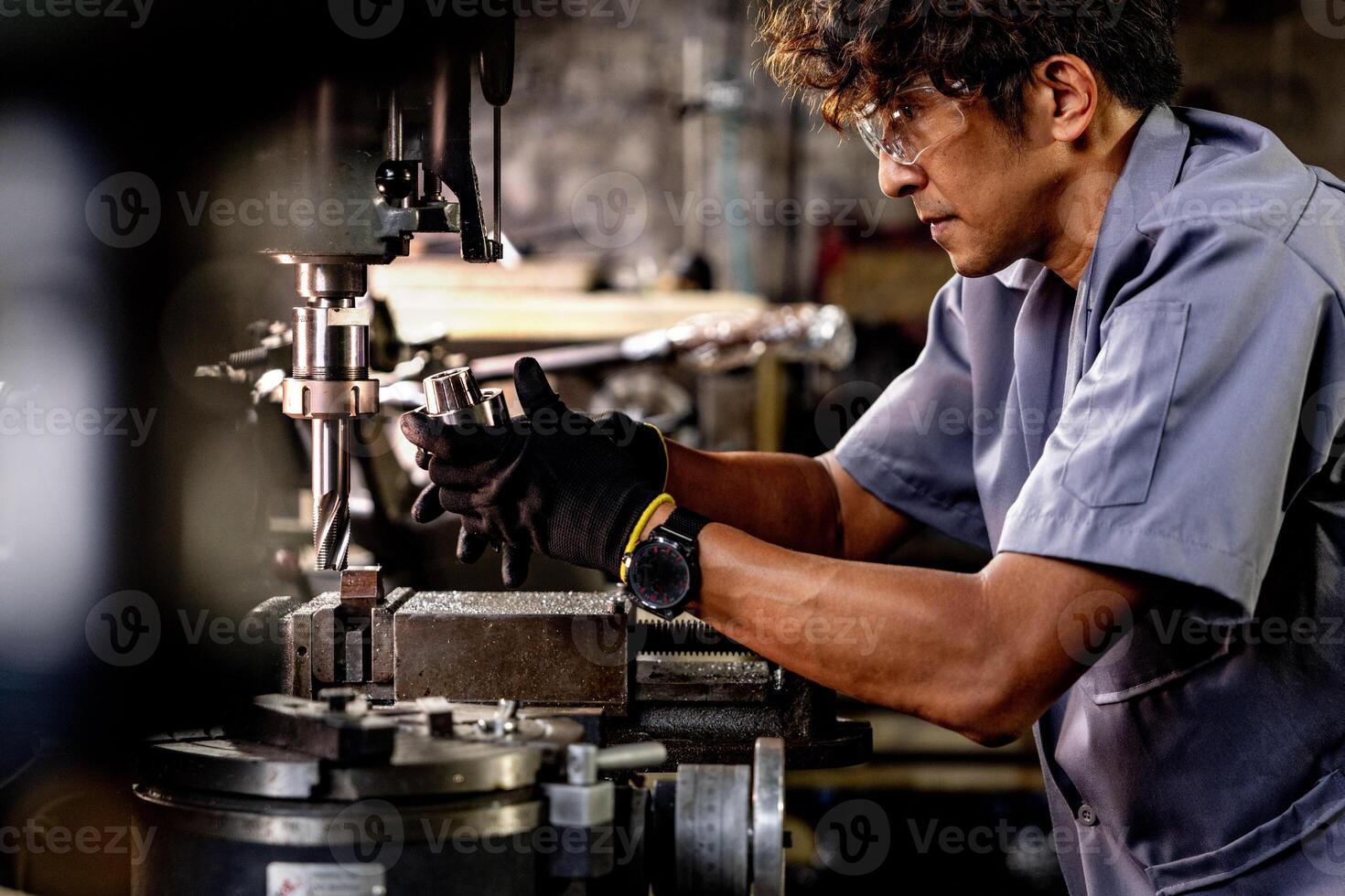 Asian worker in production plant drilling at machine. Professional worker near drilling machine on factory. finishing metal working internal steel surface on lathe grinder machine with flying sparks. photo