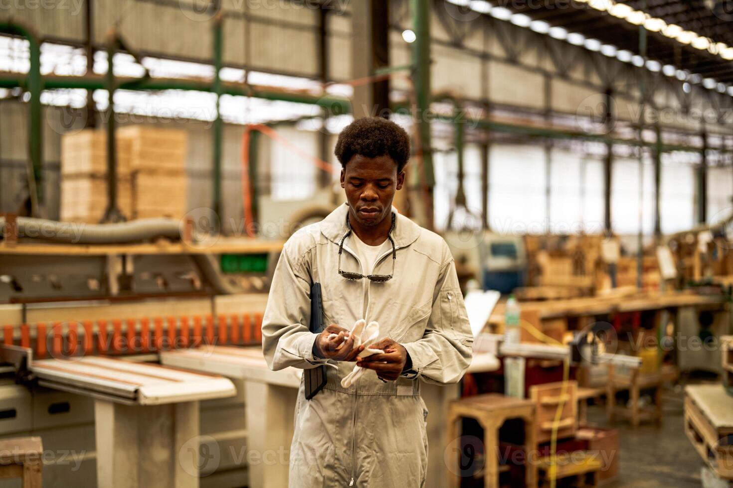 African man workers engineering standing with confidence with working suite dress and hand glove in front machine. Concept of smart industry worker operating. Wood factory produce wood palate. photo