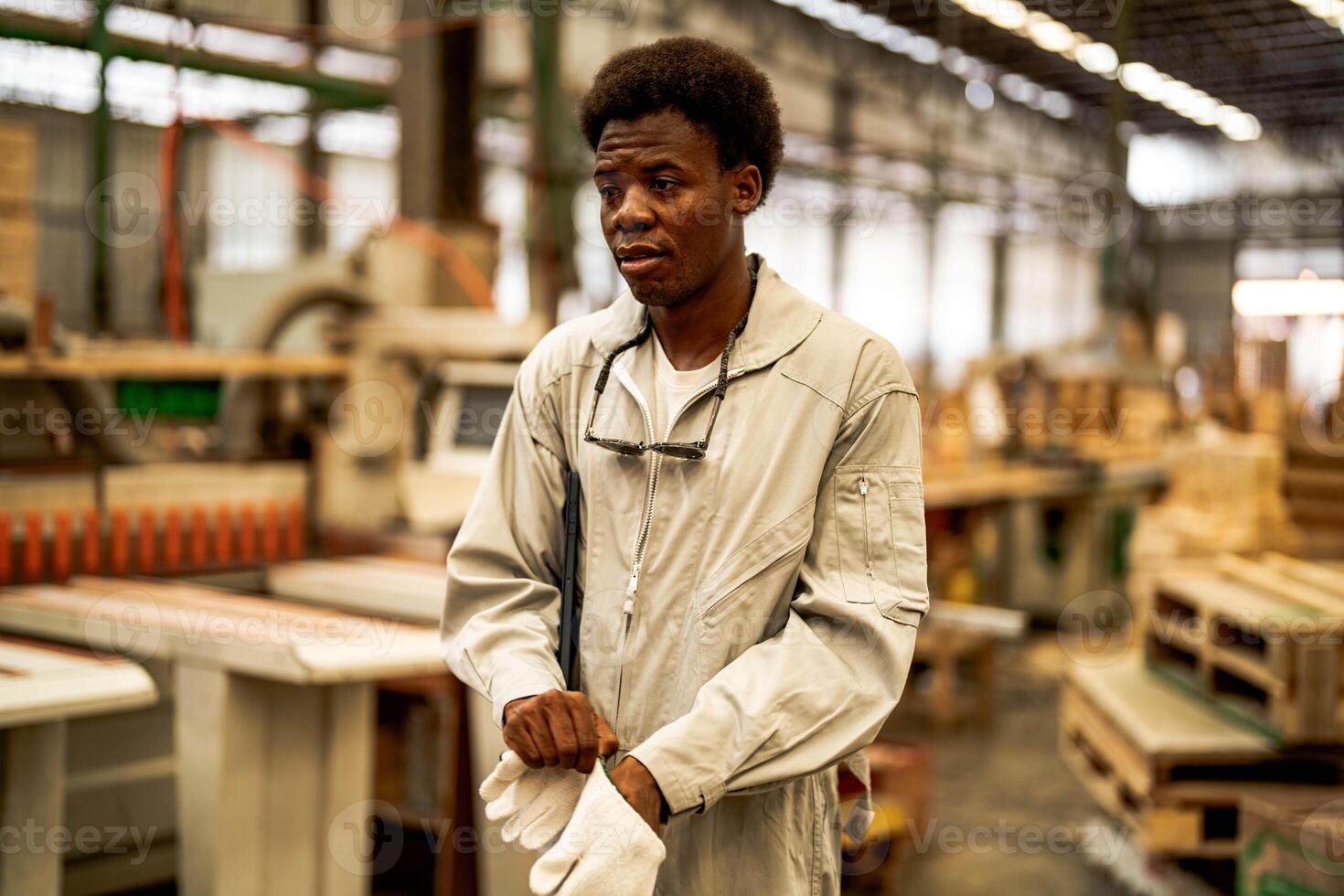 African man workers engineering standing with confidence with working suite dress and hand glove in front machine. Concept of smart industry worker operating. Wood factory produce wood palate. photo