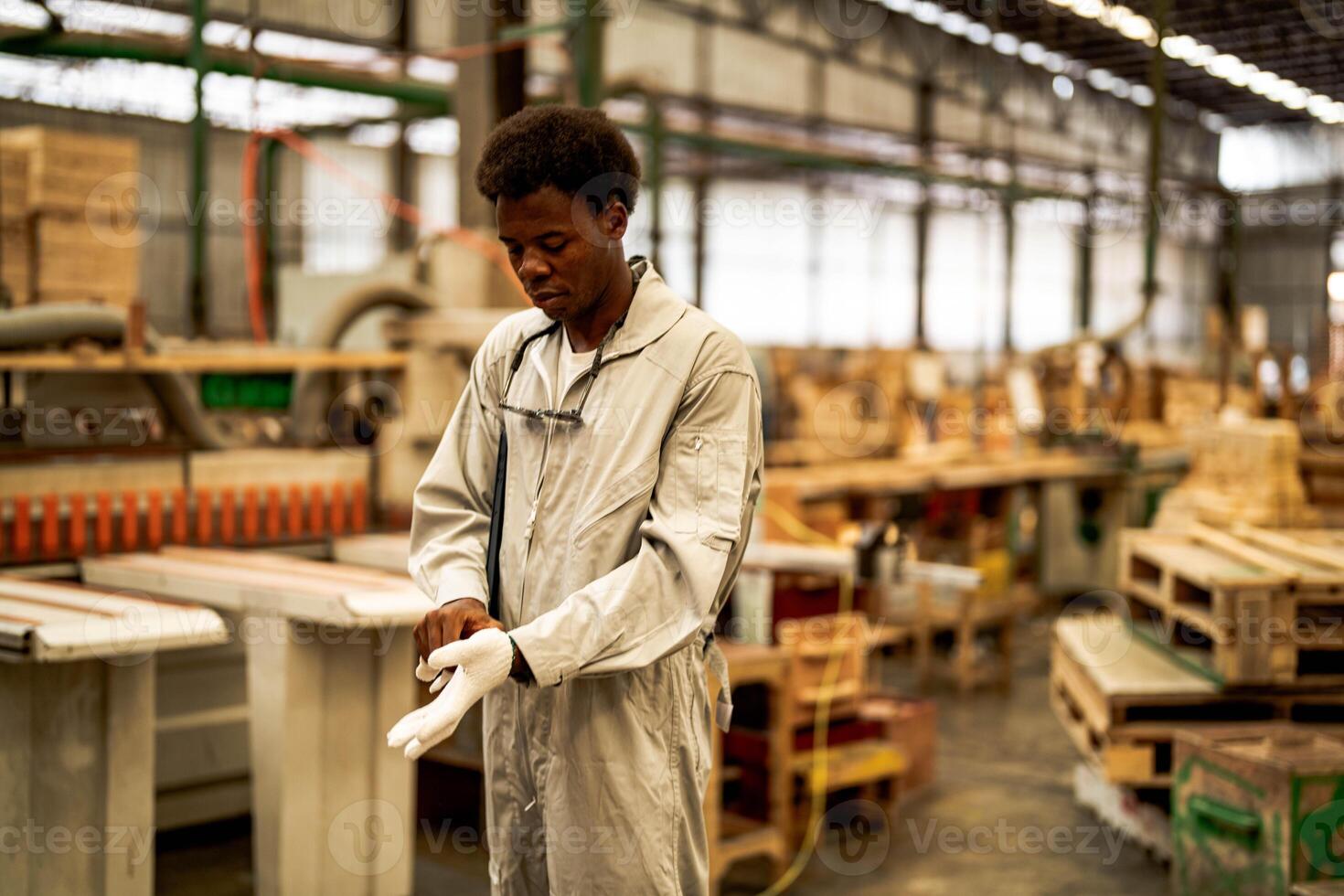 African man workers engineering standing with confidence with working suite dress and hand glove in front machine. Concept of smart industry worker operating. Wood factory produce wood palate. photo