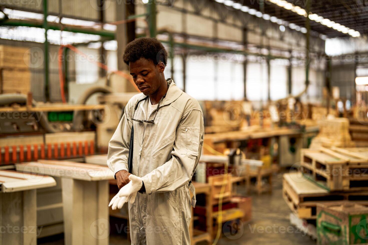 African man workers engineering standing with confidence with working suite dress and hand glove in front machine. Concept of smart industry worker operating. Wood factory produce wood palate. photo