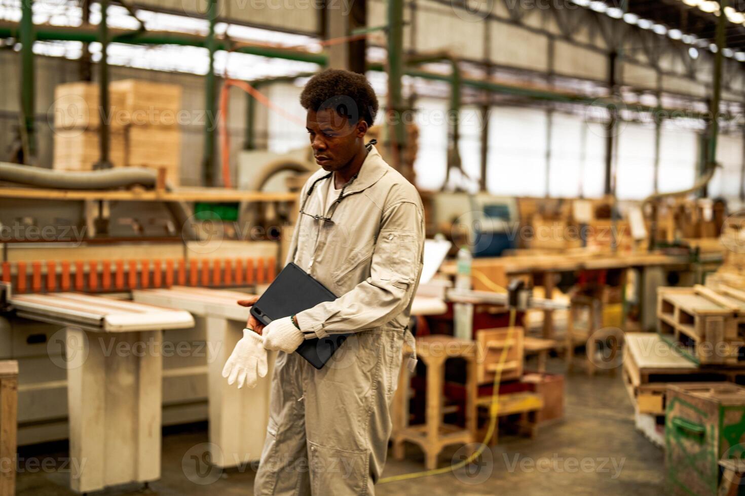 African man workers engineering standing with confidence with working suite dress and hand glove in front machine. Concept of smart industry worker operating. Wood factory produce wood palate. photo