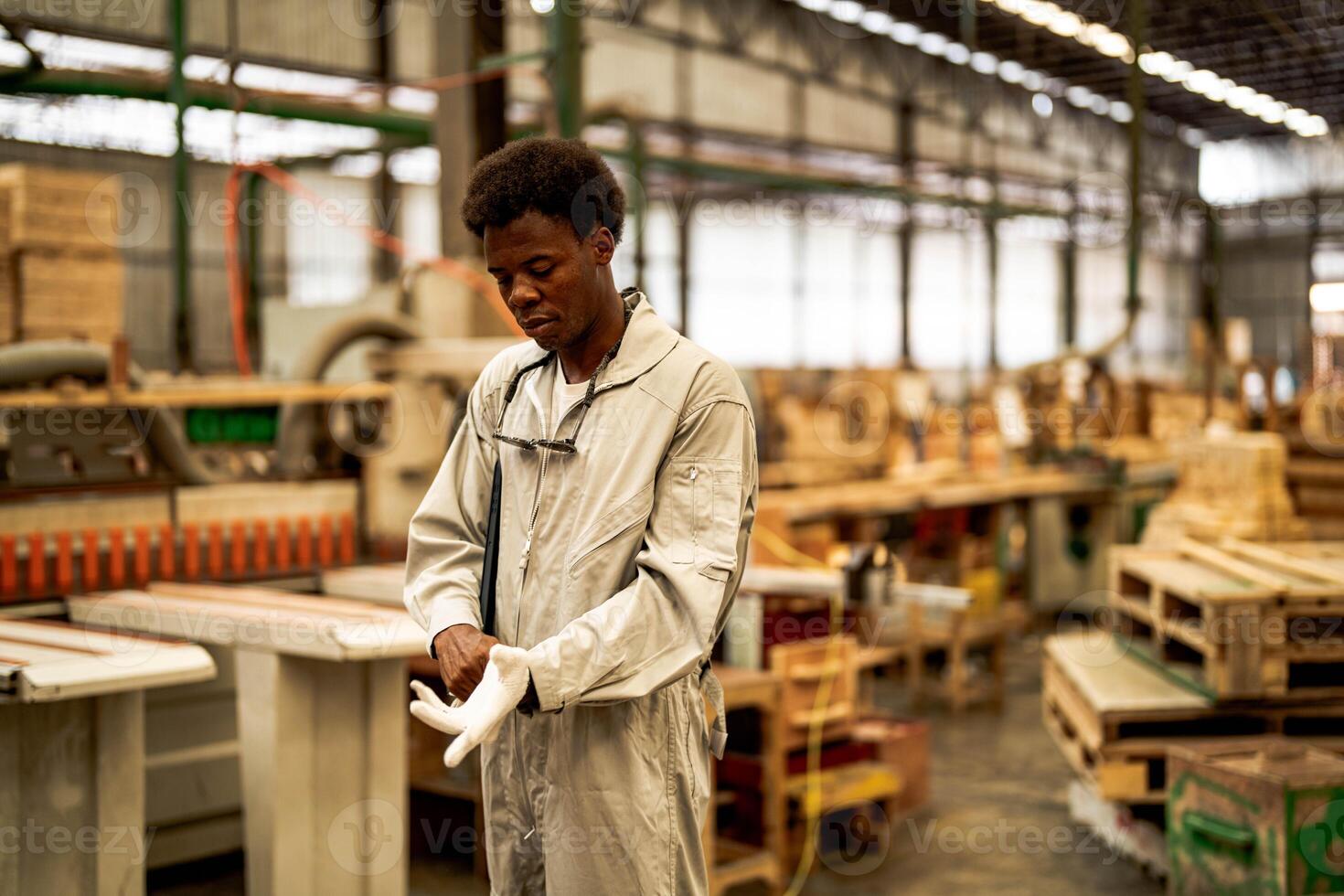 African man workers engineering standing with confidence with working suite dress and hand glove in front machine. Concept of smart industry worker operating. Wood factory produce wood palate. photo