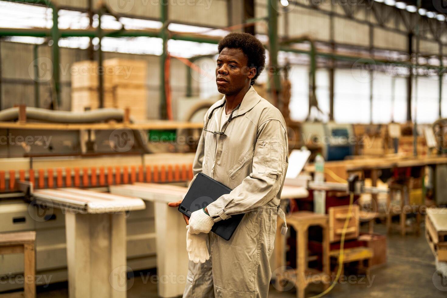 African man workers engineering standing with confidence with working suite dress and hand glove in front machine. Concept of smart industry worker operating. Wood factory produce wood palate. photo